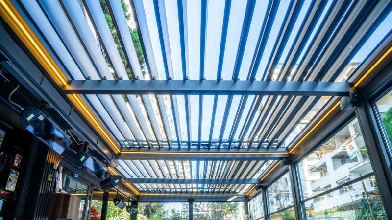 Une pergola bioclimatique ajuste l'ombre et l'air sur la terrasse.