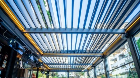 Une pergola bioclimatique ajuste l'ombre et l'air sur la terrasse.